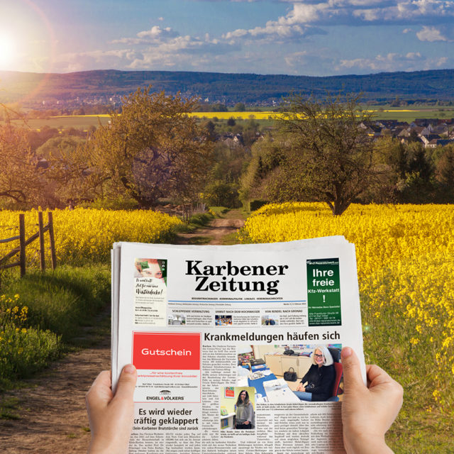 Foto: Nahaufnahme der Titelseite des Wochenblatts Karbener Zeitung mit Rapsfeld bei Sonnenschein im Hintergrund