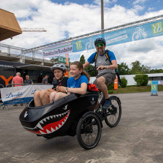 Mann kutschiert zwei Kinder mit dem Lastenrad im Hai-Style auf der Teststrecke der VELOFrankfurt