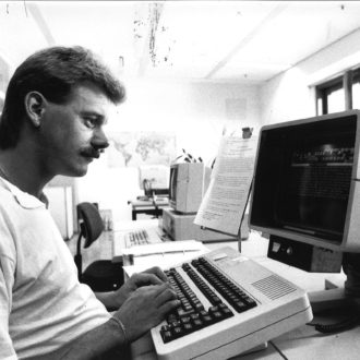 SW-Foto von einem Redakteur, der am neuen Computersystem Atex arbeitet