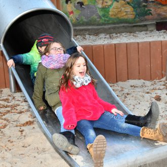 Foto: Bild von drei Kindern auf einer Rutsche