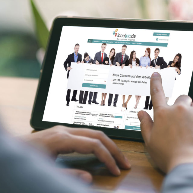 Foto: Mann scrollt auf einem Tablet und sieht sich die Website localjob.de an
