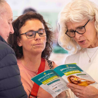 Foto: Besuchende der Messe mit Ausstellungsprogramm in der Hand