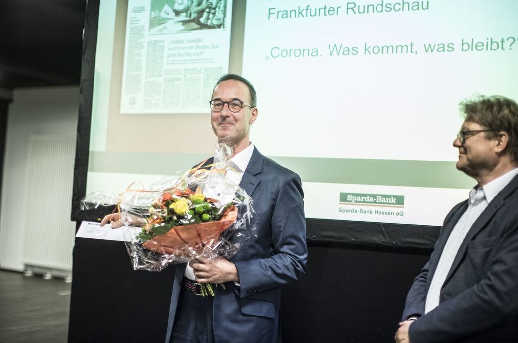 Foto: Preisträger Peter Hanack mit Blumenstrauß in der Hand