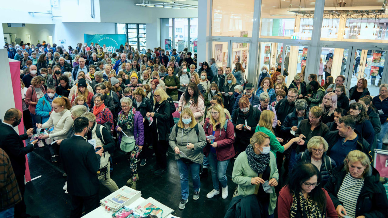 Zahlreiche Besucherinnen und Besucher drängen sich im Eingangsbereich der Messe Offenbach, um auf die Kreativ Welt 2022 zu gehen.