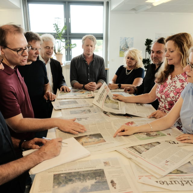 Foto: Redakteurinnen und Redakteure der FNP besprechen sich an einem Tisch