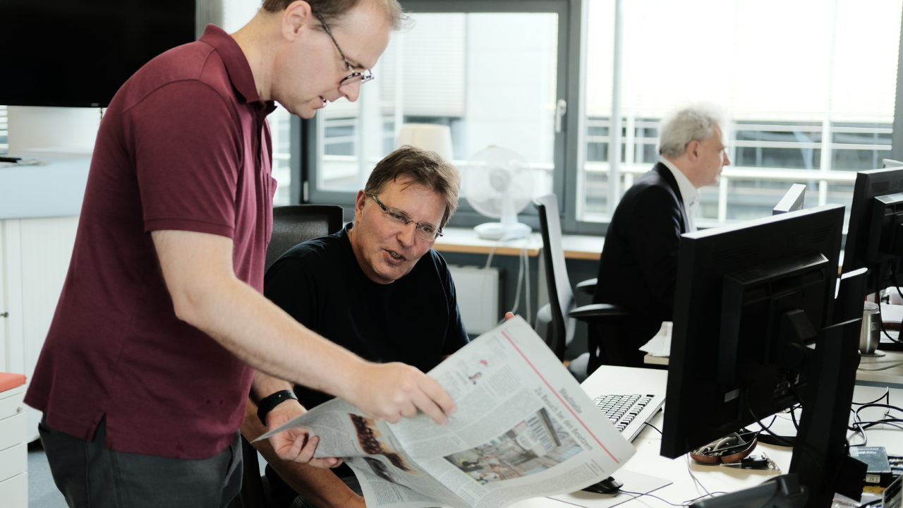 Ausschnitt aus Redaktionsalltag. Zu sehen sind Sven Müller und Achim Lederle, zwei Redakteure.