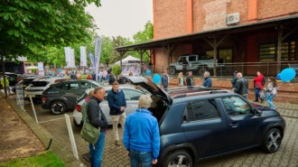 Foto: Besuchende lassen sich ein Auto zeigen