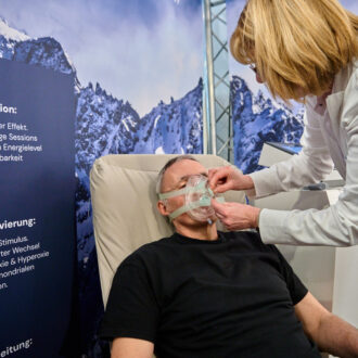 Foto: Ärztin setzt Mann Sauerstoffmaske auf