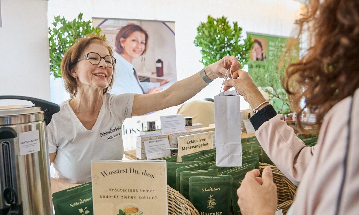 Foto: Ausstellerin bedient eine Kundin an ihrem Stand
