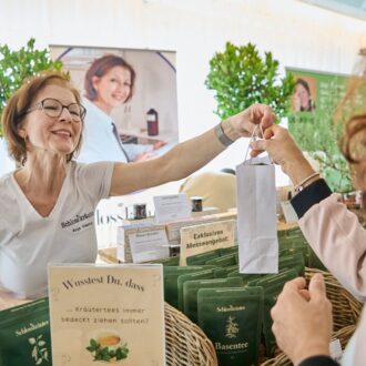 Foto: Ausstellerin bedient eine Kundin an ihrem Stand